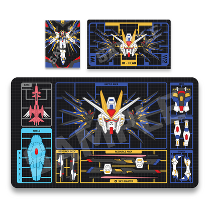 A rubber collectible playmat featuring mecha battle graphics, shown alongside matching sleeves and a sturdy deck box. The design includes a central white and red robot head, blue weapon effects, yellow grid lines, and labeled sections such as battle area, shield, and reserve deck on a black background.
