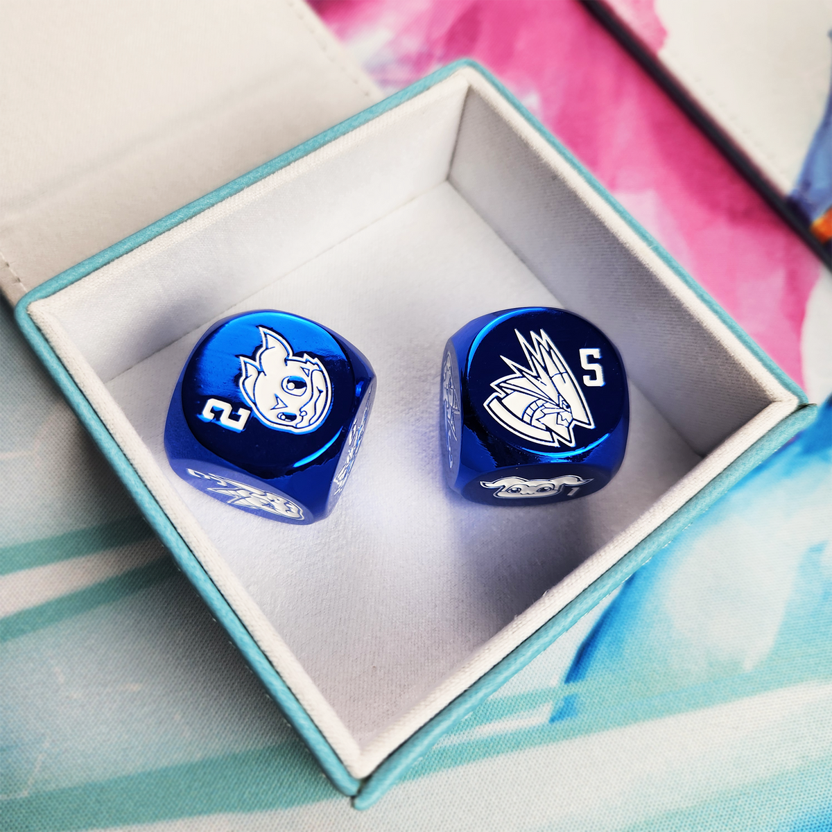 Metallic blue dice, each side featuring a unique character, in the detachable dice tray. 